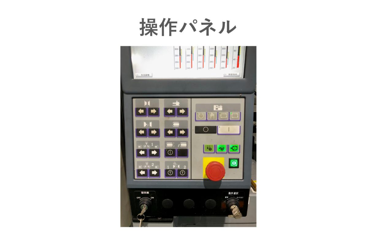 射出成形機の操作パネルにある各種制御ボタンと緊急停止スイッチの写真